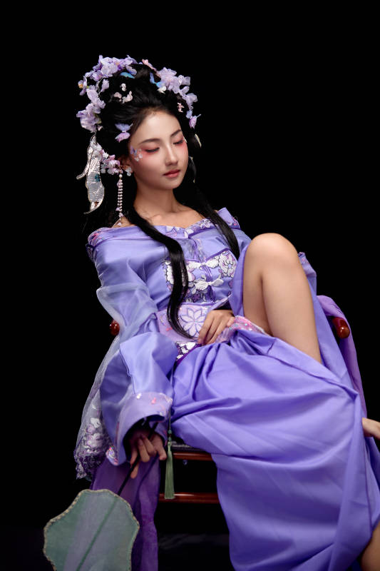 身着簪花仕女装扮坐在木桌上的东方女性图片