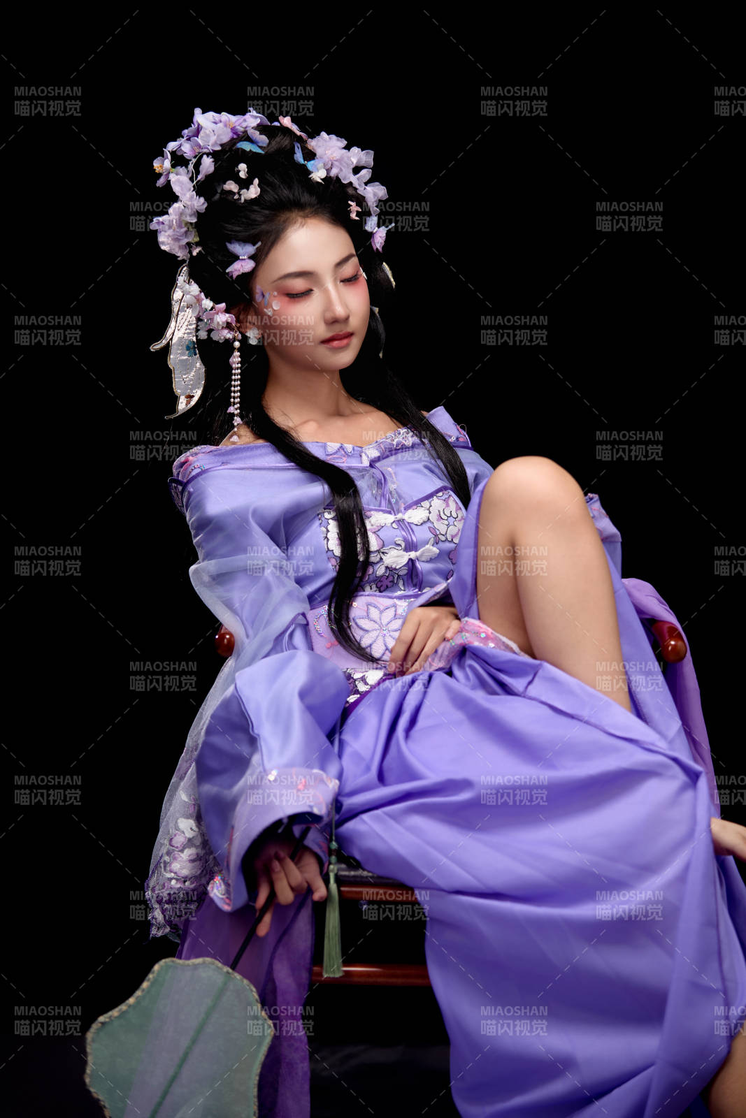 身着簪花仕女装扮坐在木桌上的东方女性图片