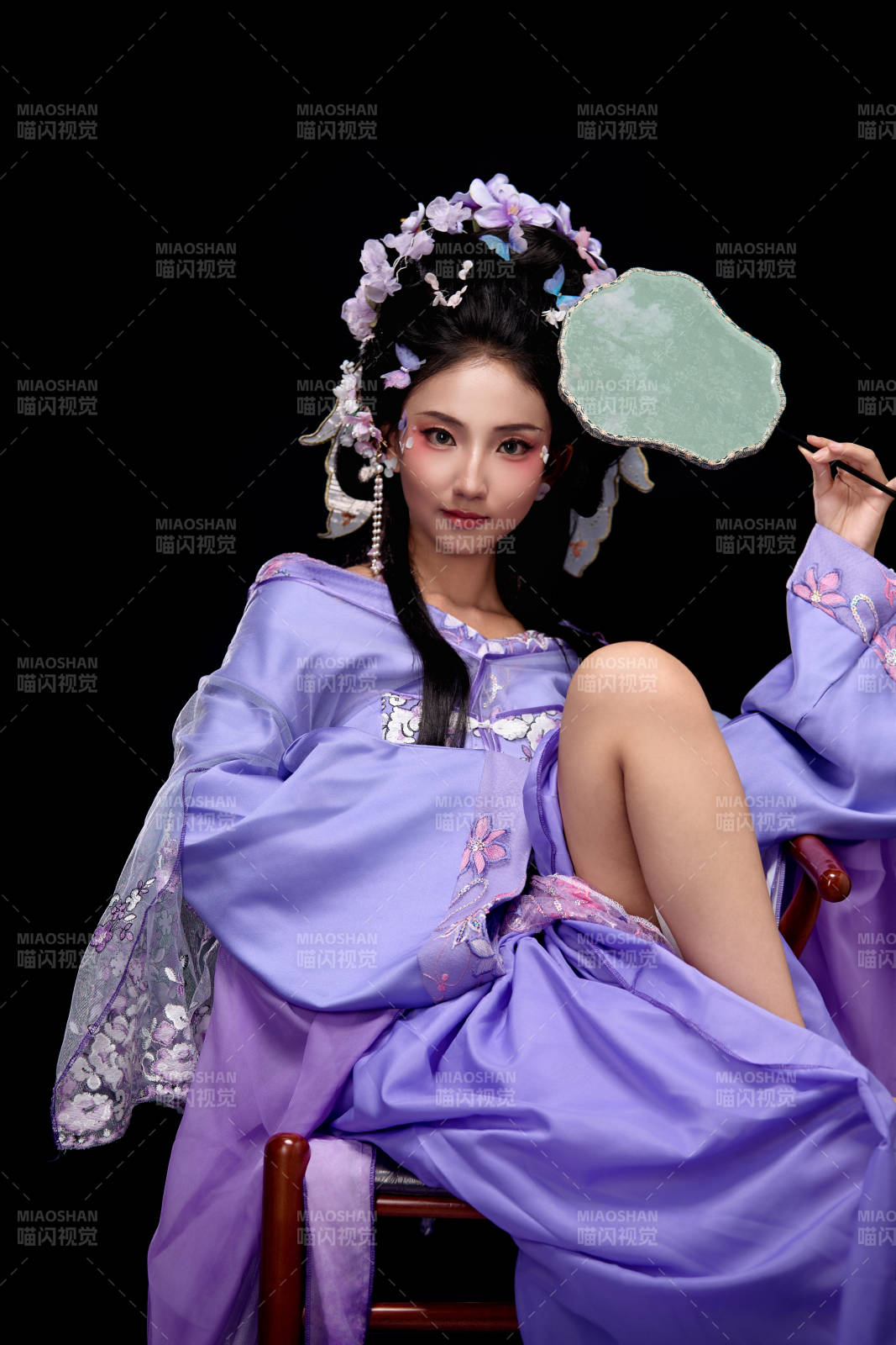 身着簪花仕女装扮坐在木桌上的东方女性图片