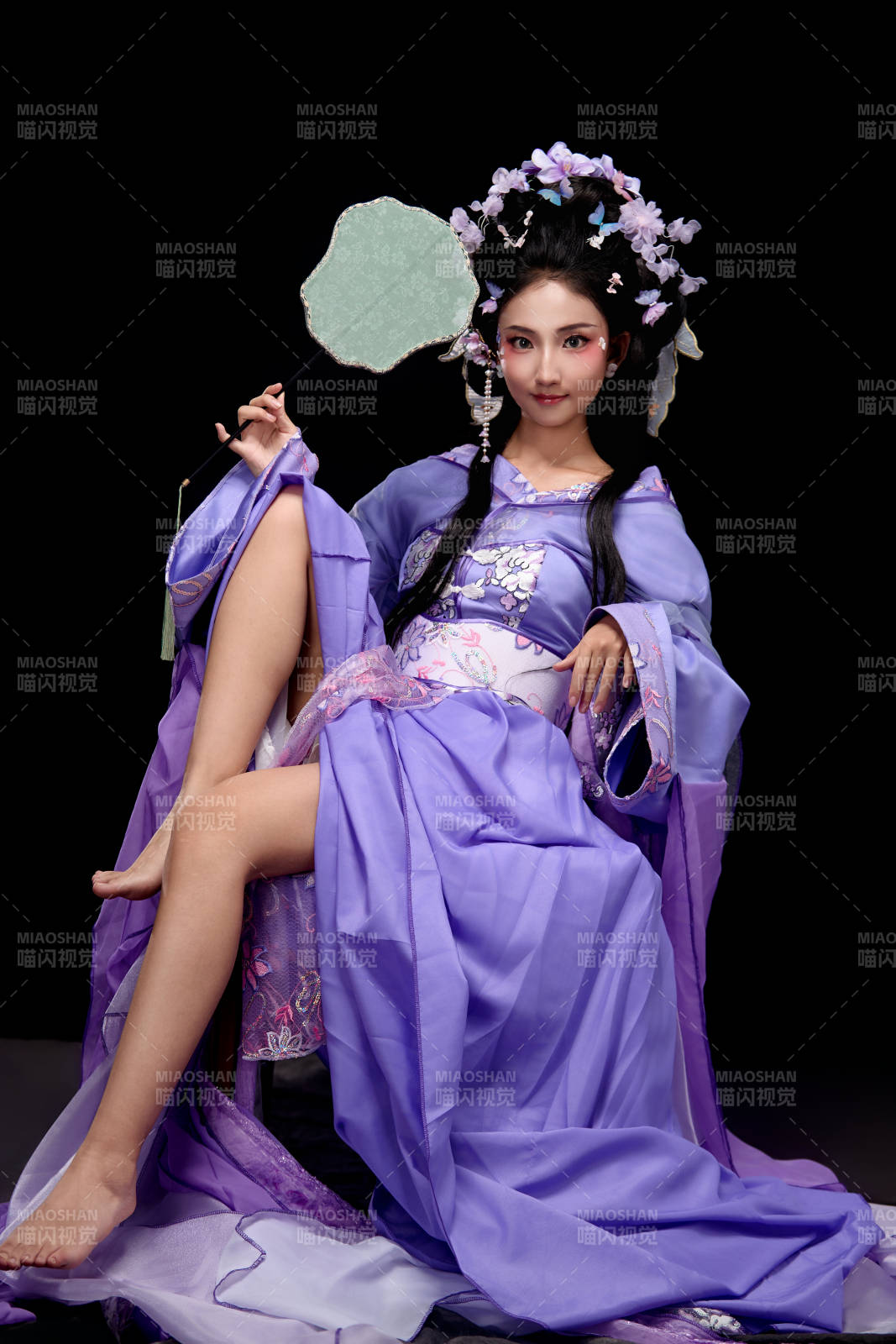 身着簪花仕女装扮坐在木桌上的东方女性图片