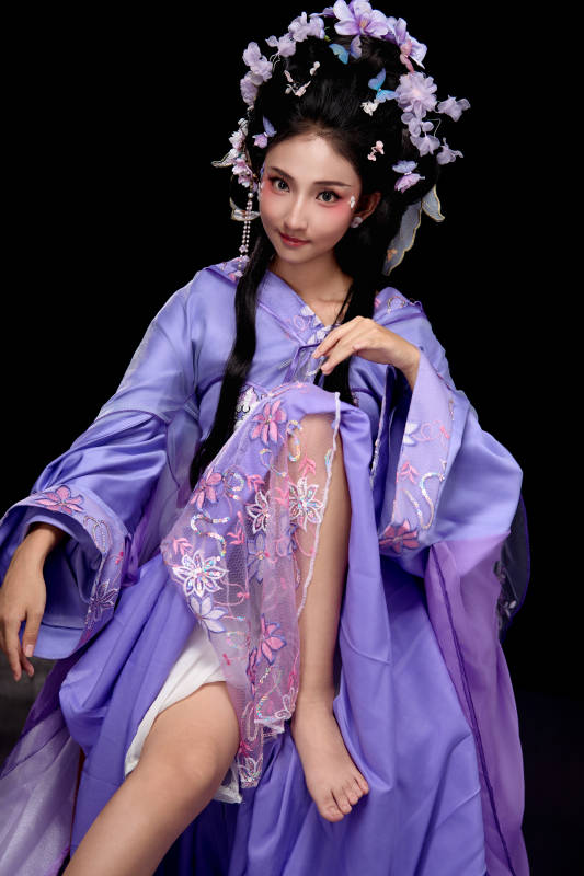 身着簪花仕女装扮坐在木桌上的东方女性图片