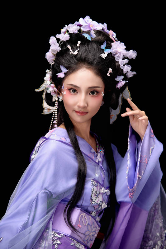 身着簪花仕女装扮坐在木桌上的东方女性图片