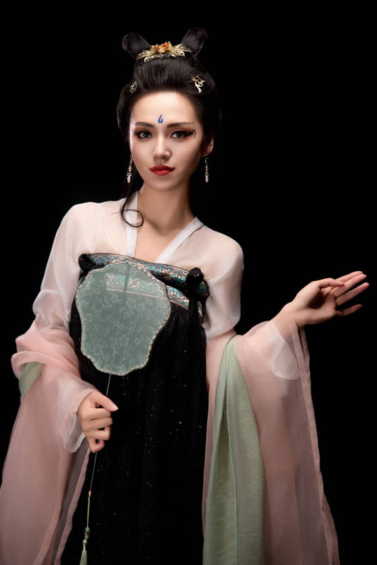 手持轻扇展示唐代服饰妆容造型的东方女性图片