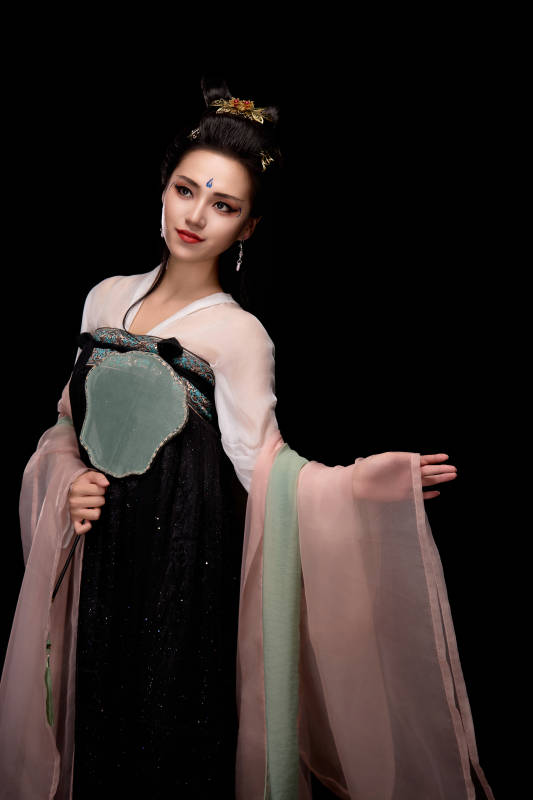 手持轻扇展示唐代服饰妆容造型的东方女性图片