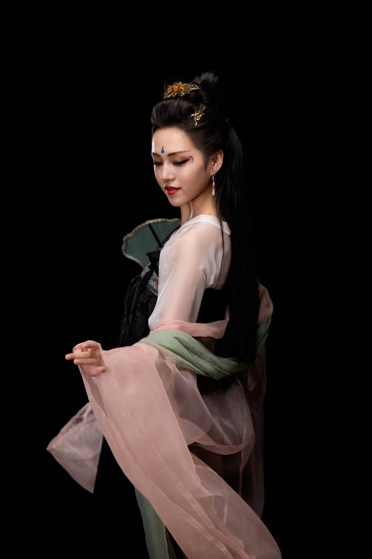 手持轻扇展示唐代服饰妆容造型的东方女性图片