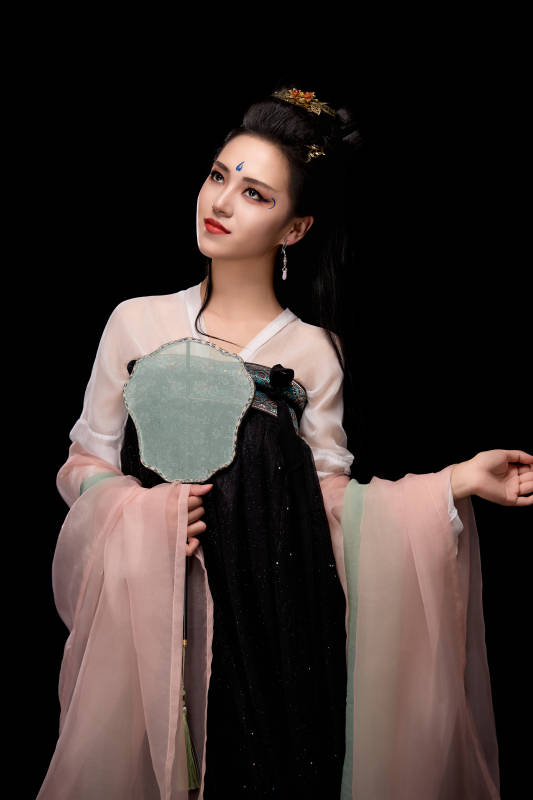 手持轻扇展示唐代服饰妆容造型的东方女性图片