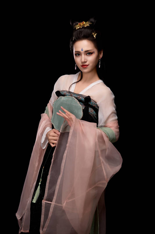 手持轻扇展示唐代服饰妆容造型的东方女性图片