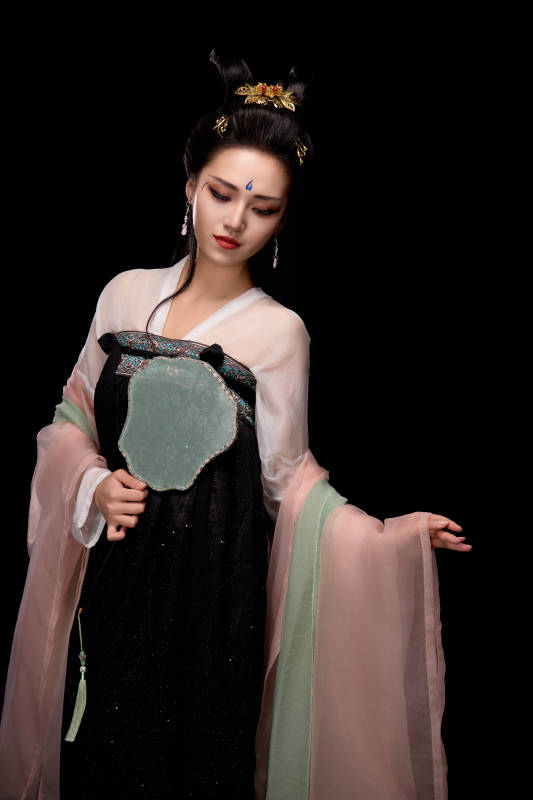手持轻扇展示唐代服饰妆容造型的东方女性图片