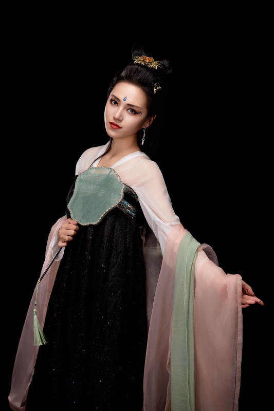 手持轻扇展示唐代服饰妆容造型的东方女性图片