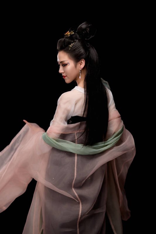 手持轻扇展示唐代服饰妆容造型的东方女性图片