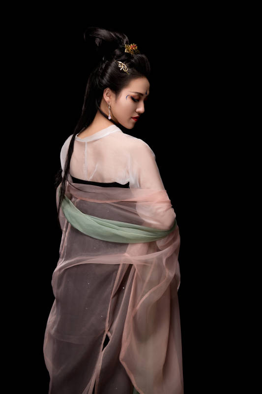 手持轻扇展示唐代服饰妆容造型的东方女性图片