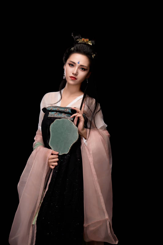 手持轻扇展示唐代服饰妆容造型的东方女性图片