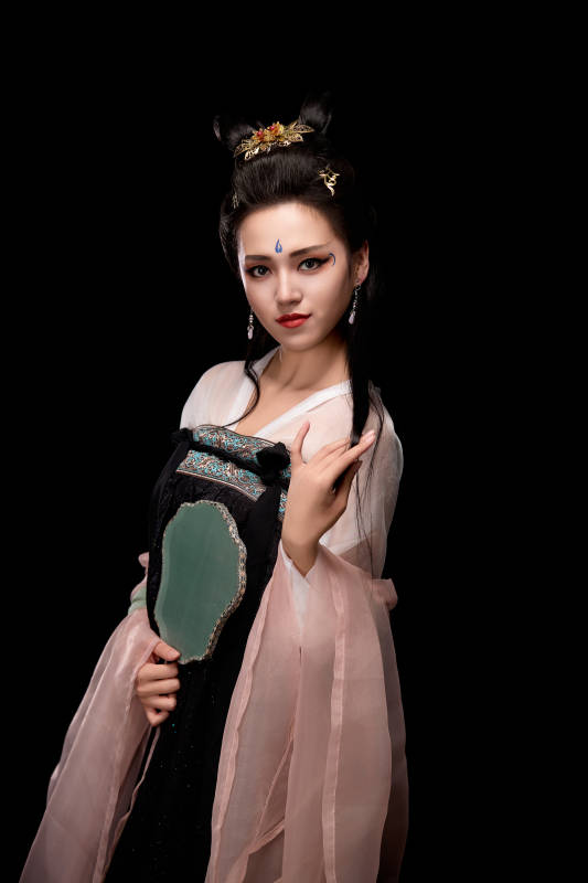 手持轻扇展示唐代服饰妆容造型的东方女性图片
