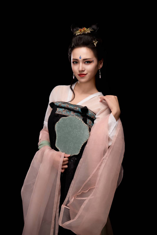 手持轻扇展示唐代服饰妆容造型的东方女性图片