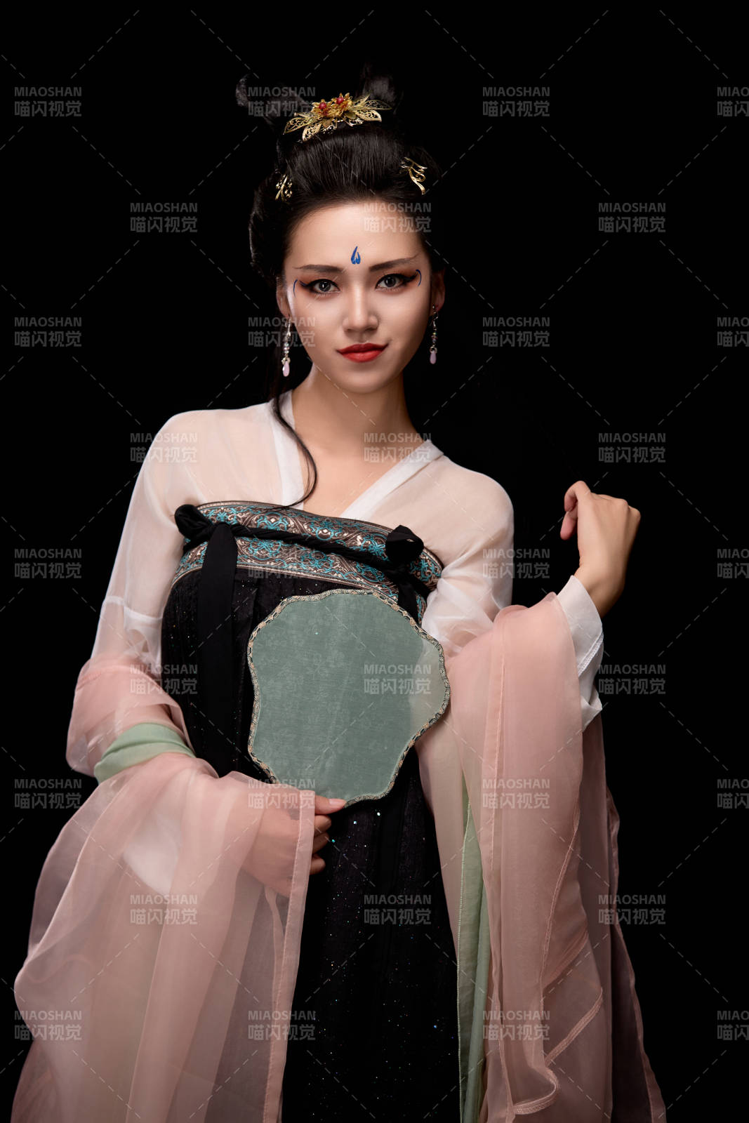 手持轻扇展示唐代服饰妆容造型的东方女性图片