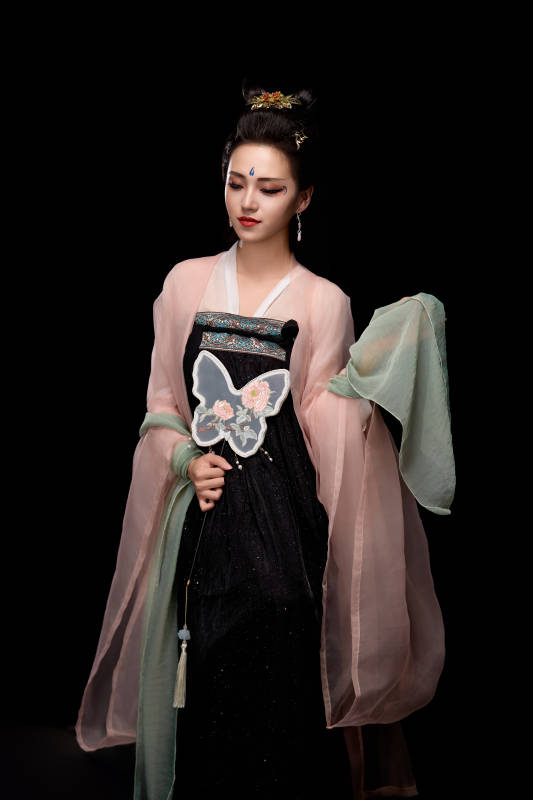 手持蝶扇展示唐代服饰妆容造型的东方女性图片
