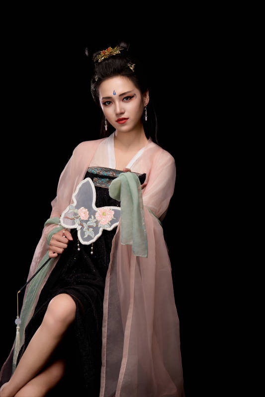 手持蝶扇展示唐代服饰妆容造型的东方女性图片