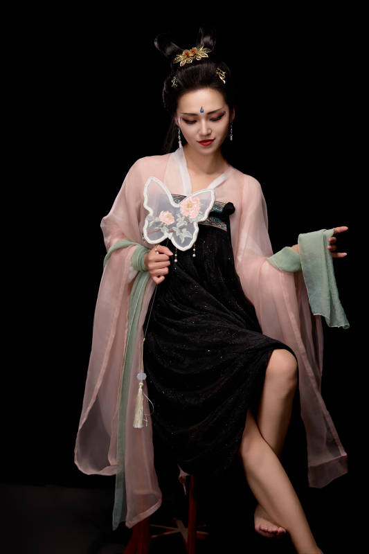 手持蝶扇展示唐代服饰妆容造型的东方女性图片