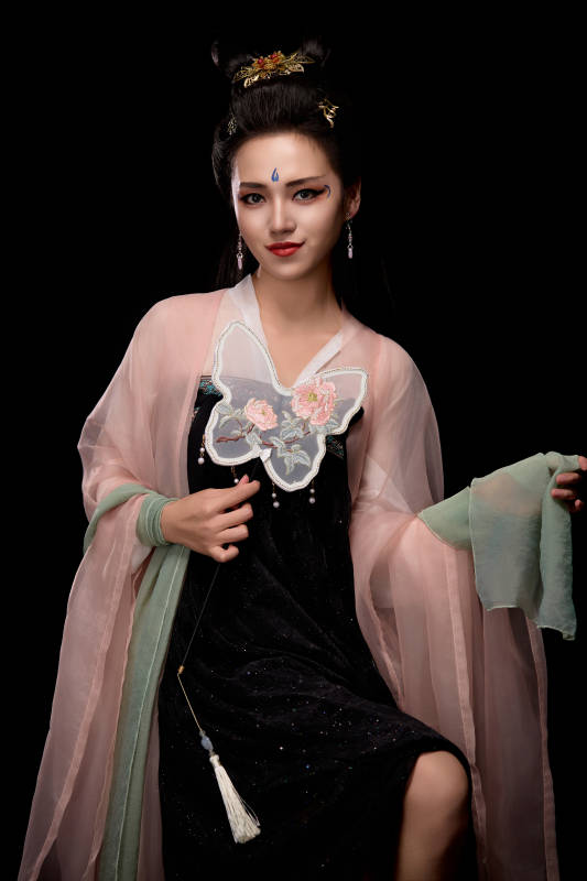 手持蝶扇展示唐代服饰妆容造型的东方女性图片