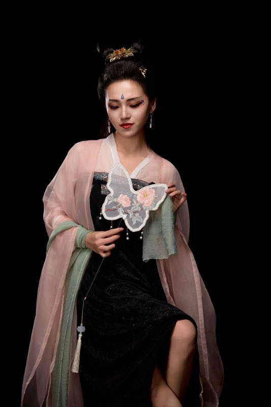 手持蝶扇展示唐代服饰妆容造型的东方女性图片