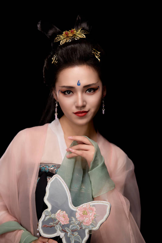 手持蝶扇展示唐代服饰妆容造型的东方女性图片