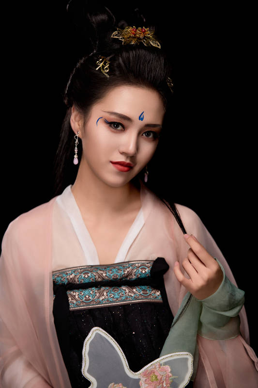 手持蝶扇展示唐代服饰妆容造型的东方女性图片