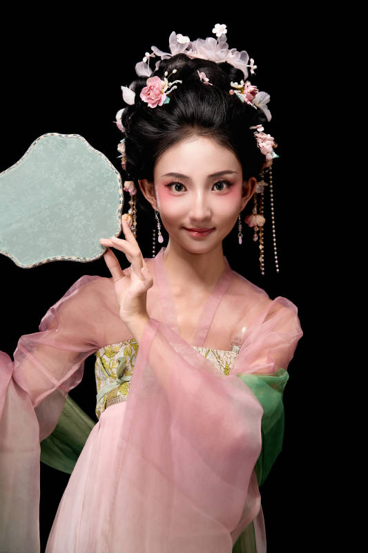 身着唐代宫廷簪花仕女服手持轻扇的女性图片