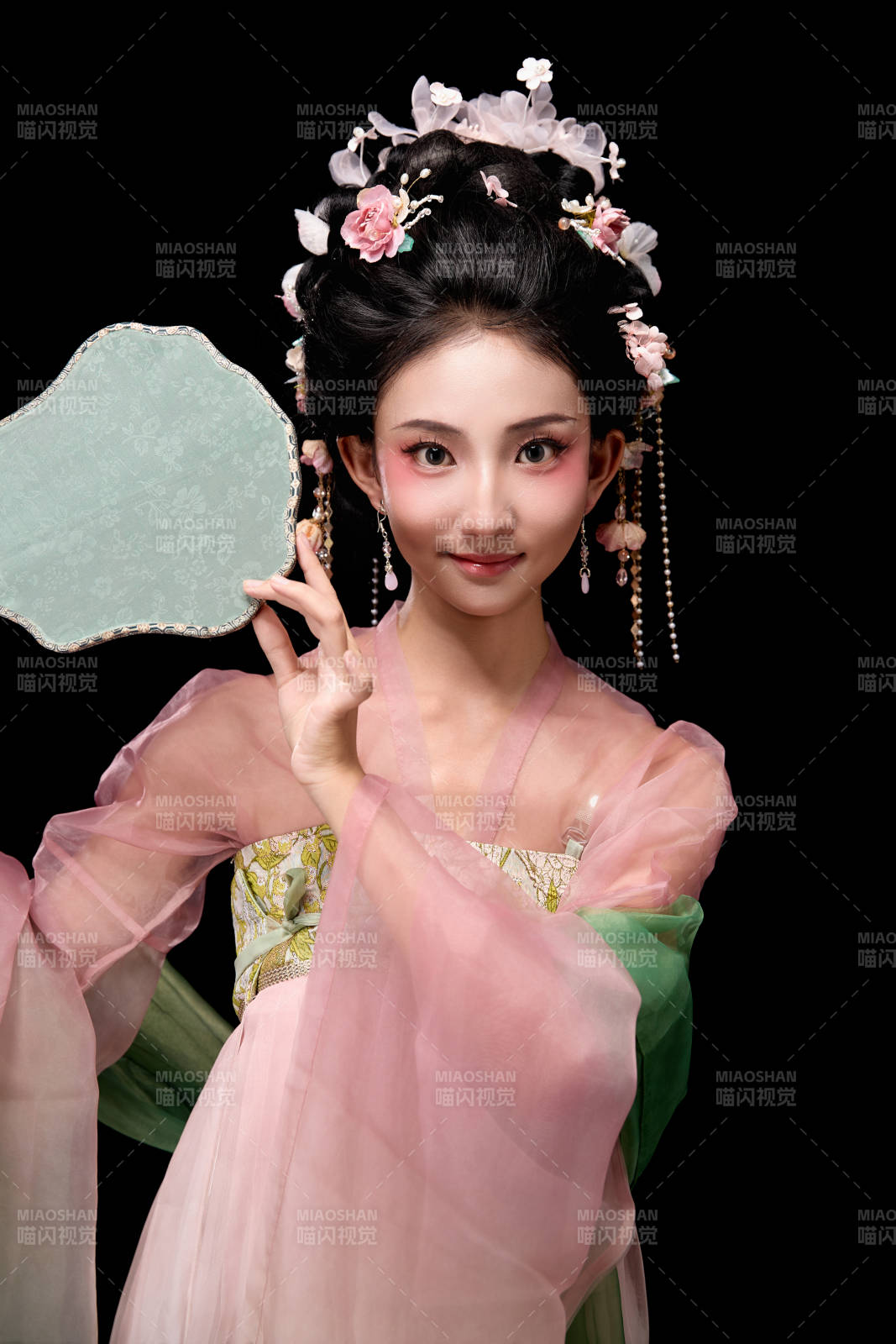 身着唐代宫廷簪花仕女服手持轻扇的女性图片