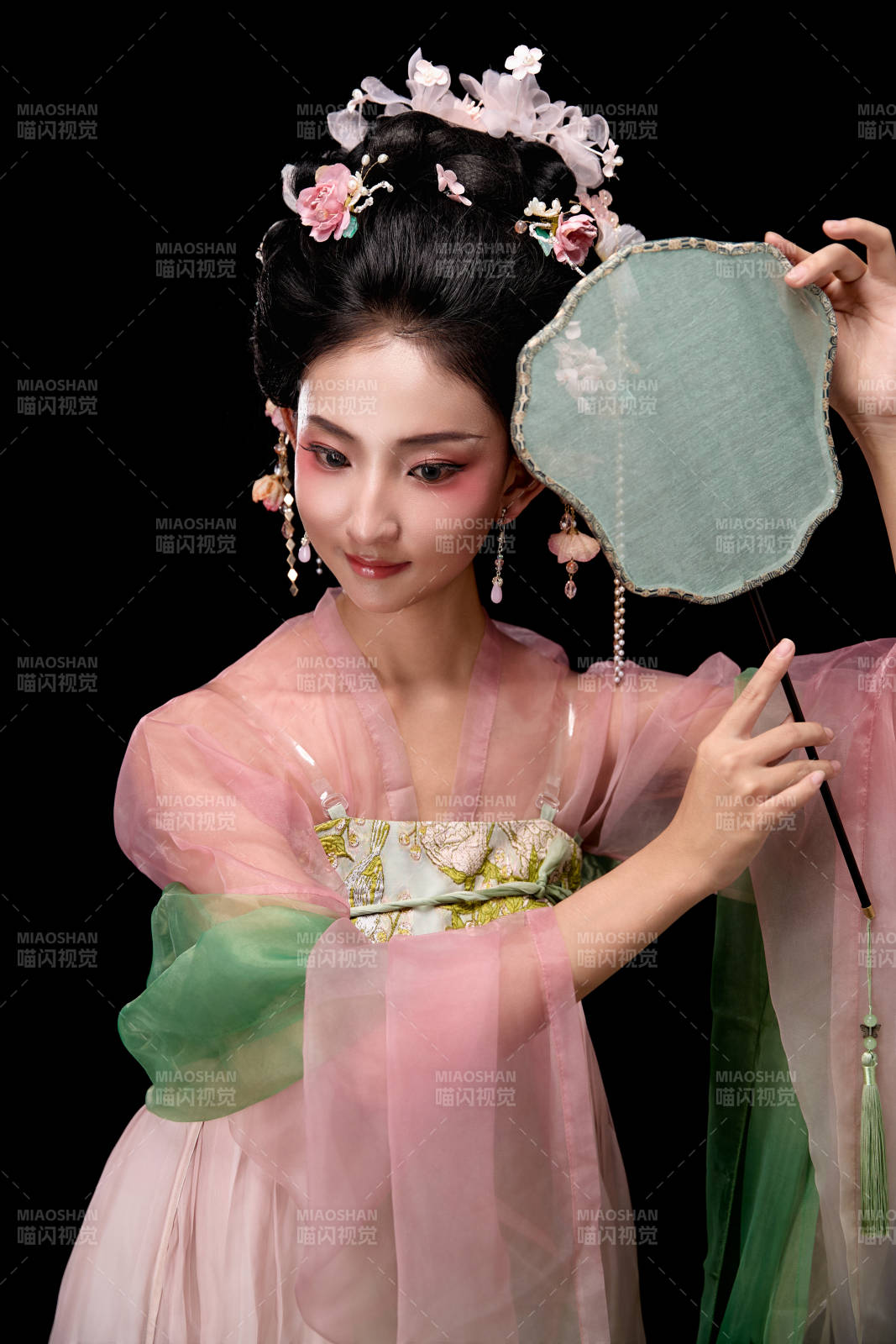 身着唐代宫廷簪花仕女服手持轻扇的女性图片