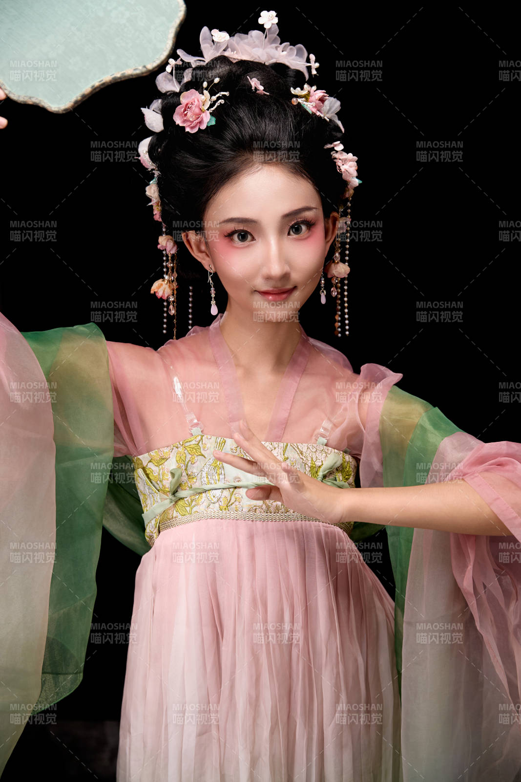 身着唐代宫廷簪花仕女服手持轻扇的女性图片