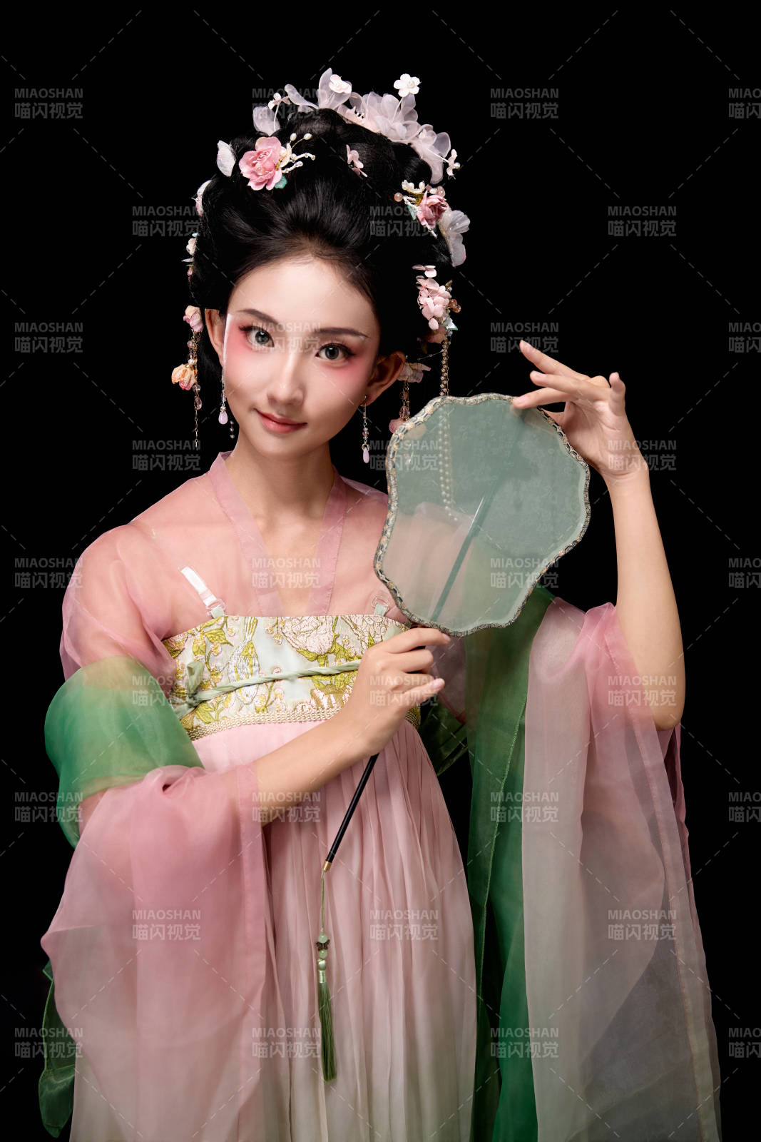 身着唐代宫廷簪花仕女服手持轻扇的女性图片