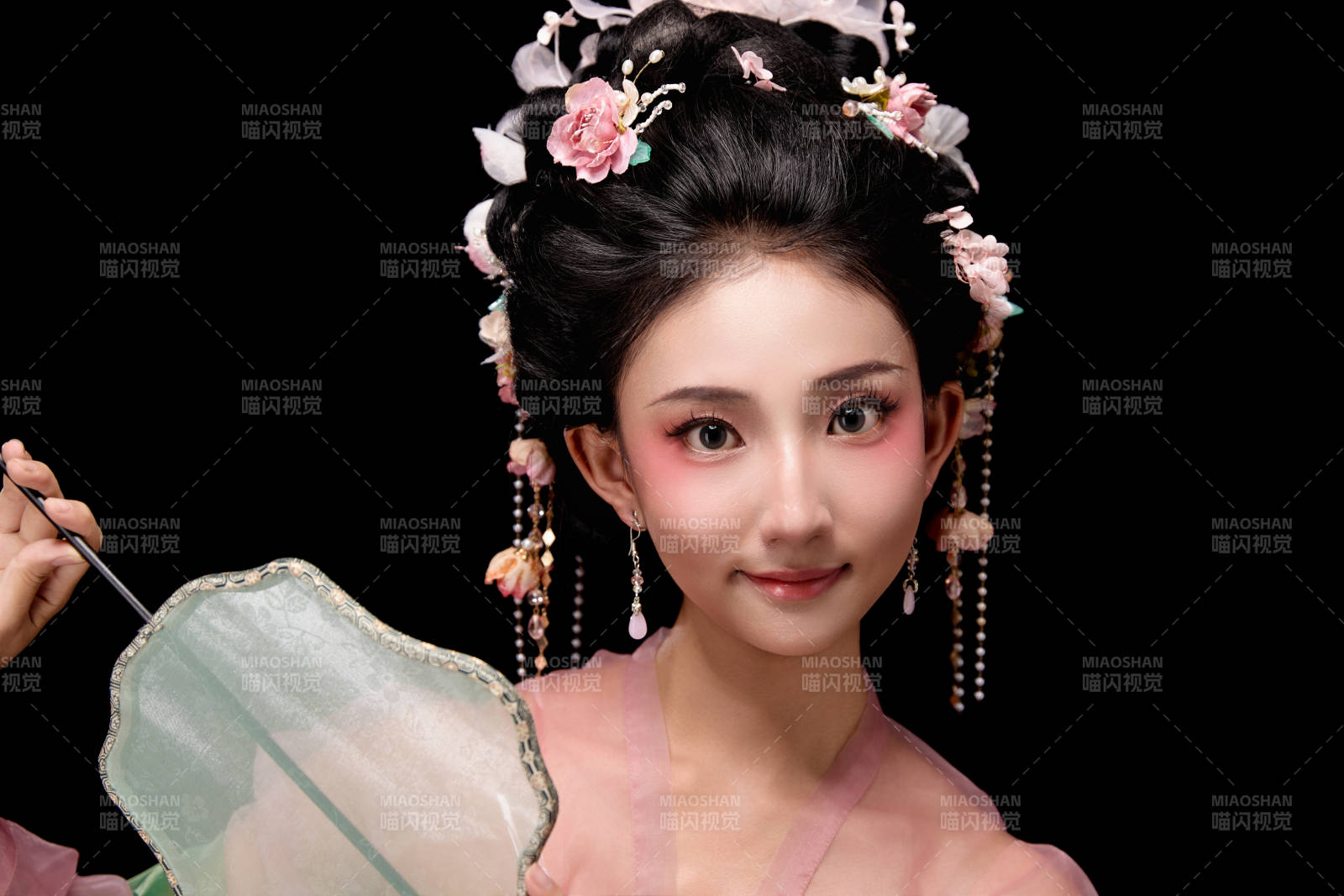 身着唐代宫廷簪花仕女服手持轻扇的女性图片