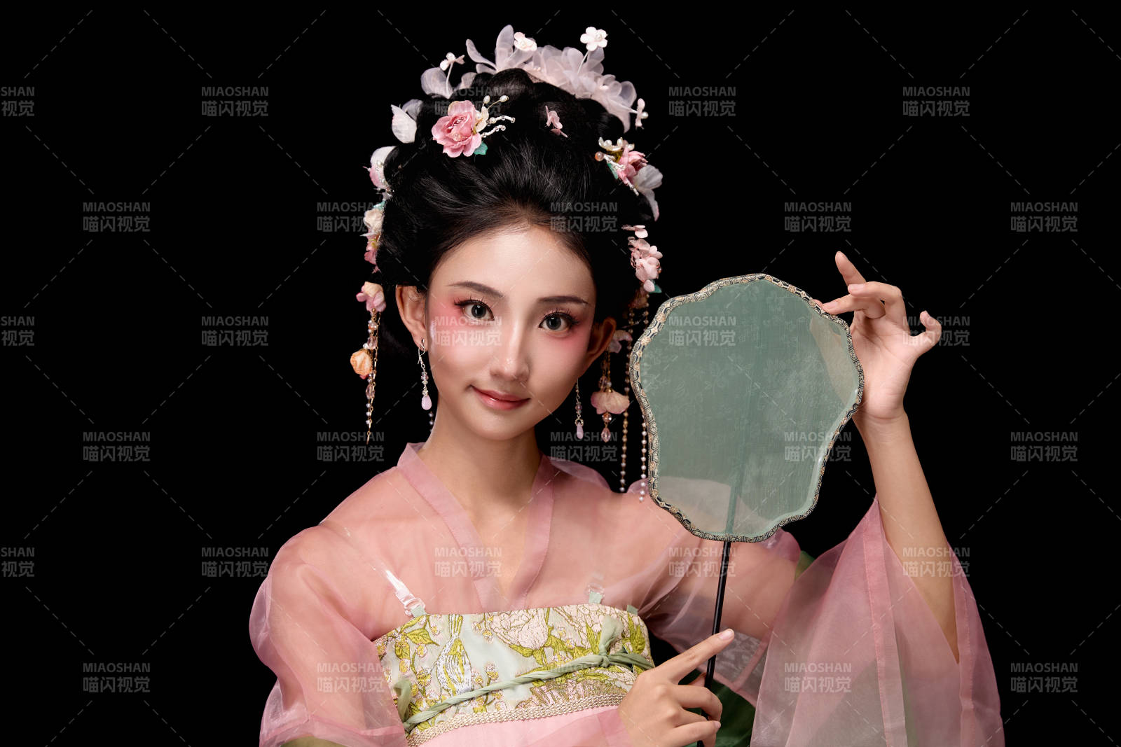 身着唐代宫廷簪花仕女服手持轻扇的女性图片