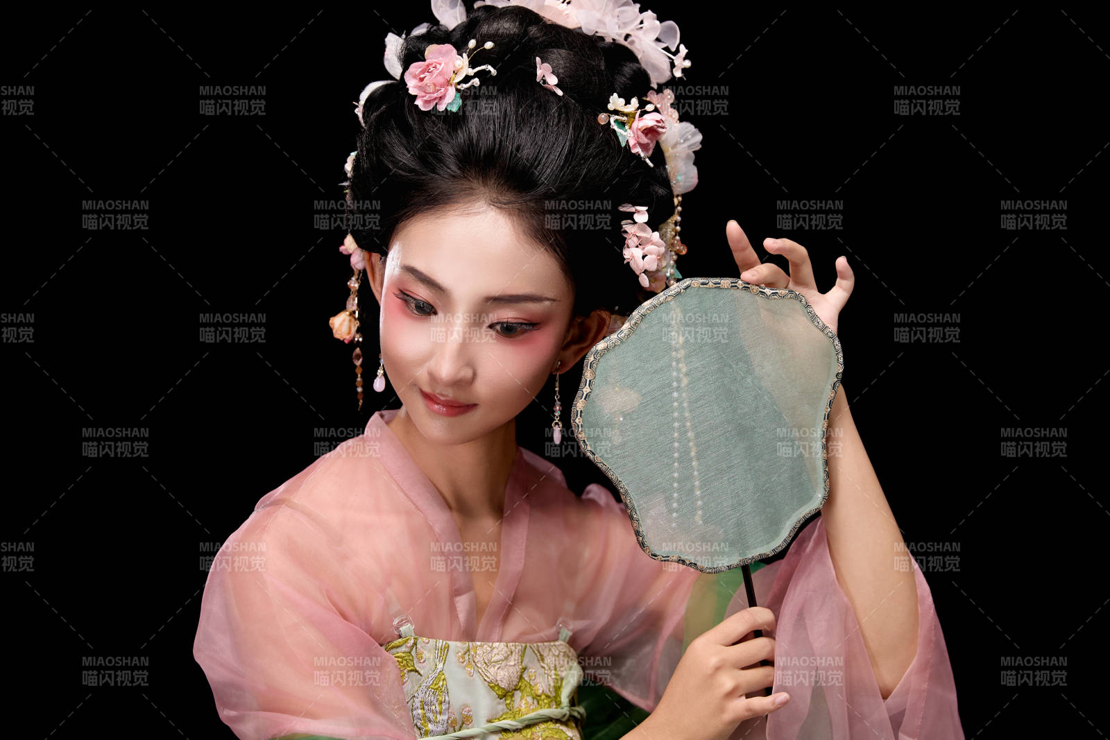 身着唐代宫廷簪花仕女服手持轻扇的女性图片