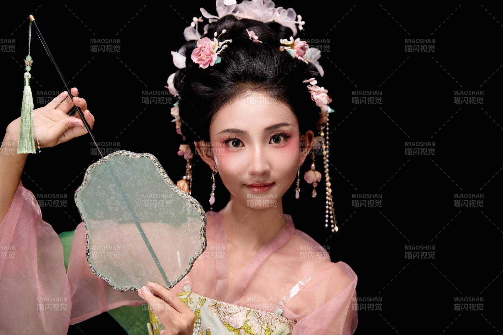 身着唐代宫廷簪花仕女服手持轻扇的女性图片