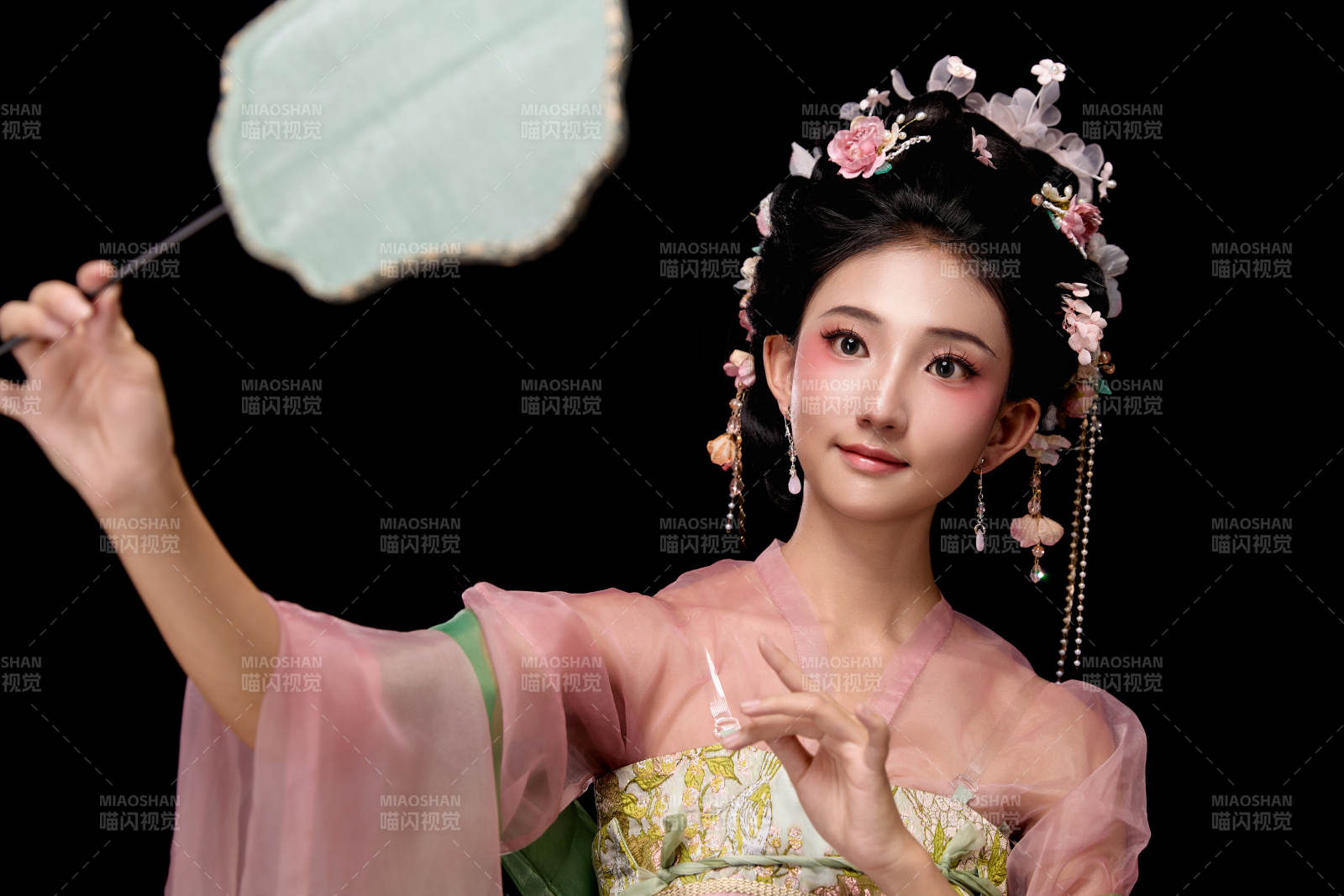 身着唐代宫廷簪花仕女服手持轻扇的女性图片