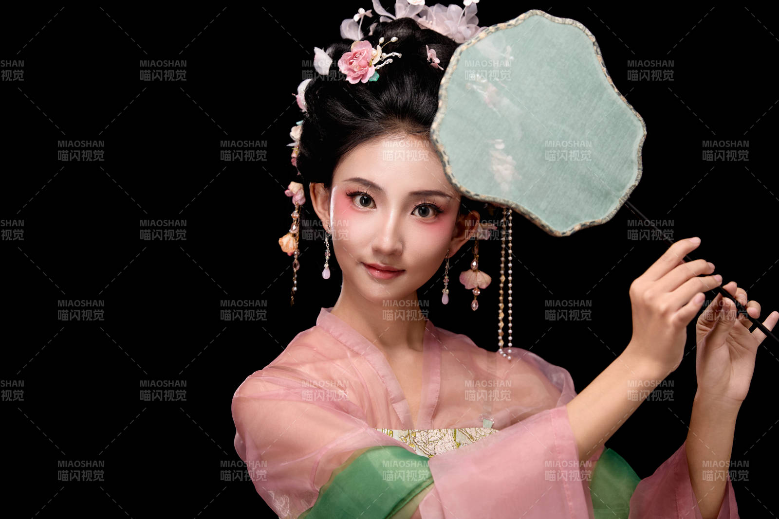 身着唐代宫廷簪花仕女服手持轻扇的女性图片