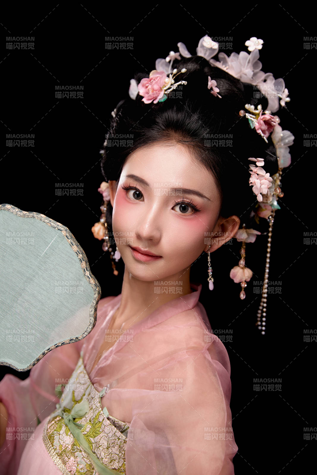 身着唐代宫廷簪花仕女服手持轻扇的女性图片