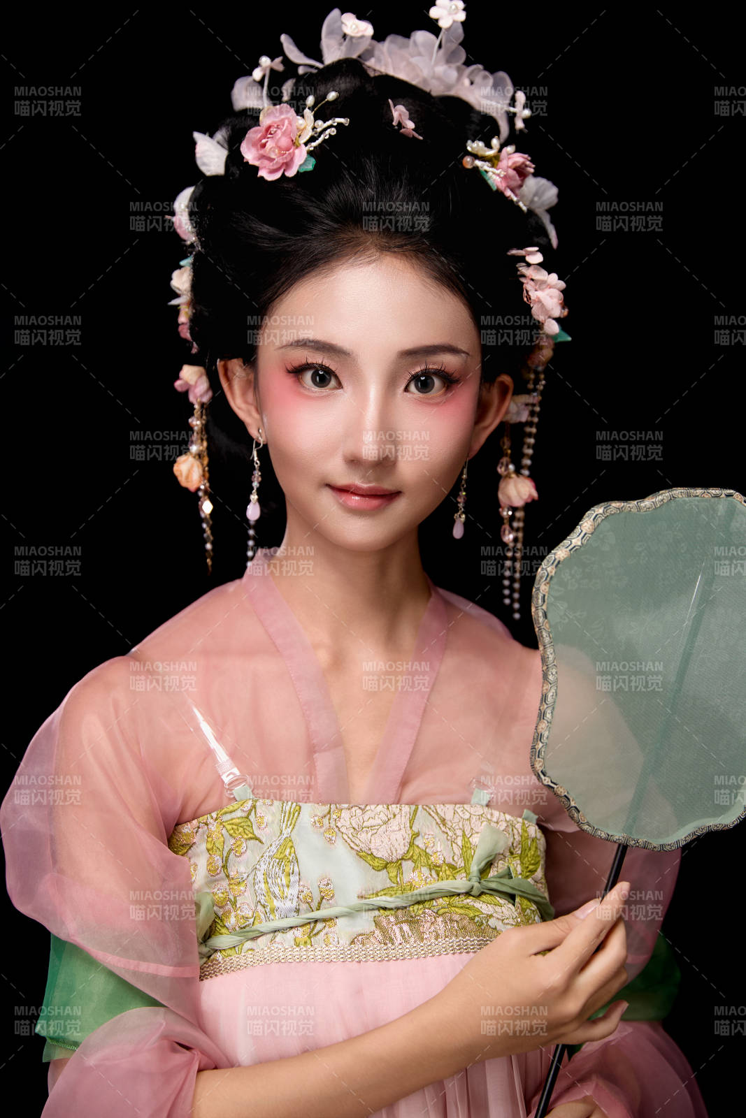 身着唐代宫廷簪花仕女服手持轻扇的女性图片