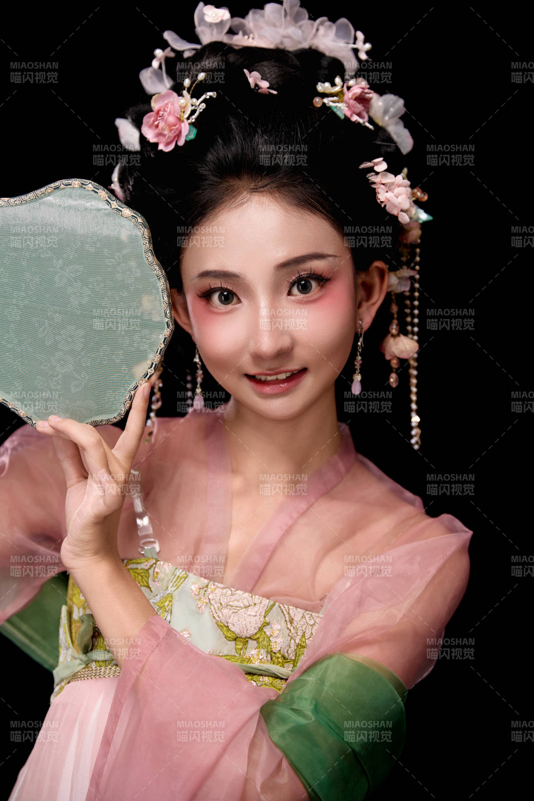 身着唐代宫廷簪花仕女服手持轻扇的女性图片