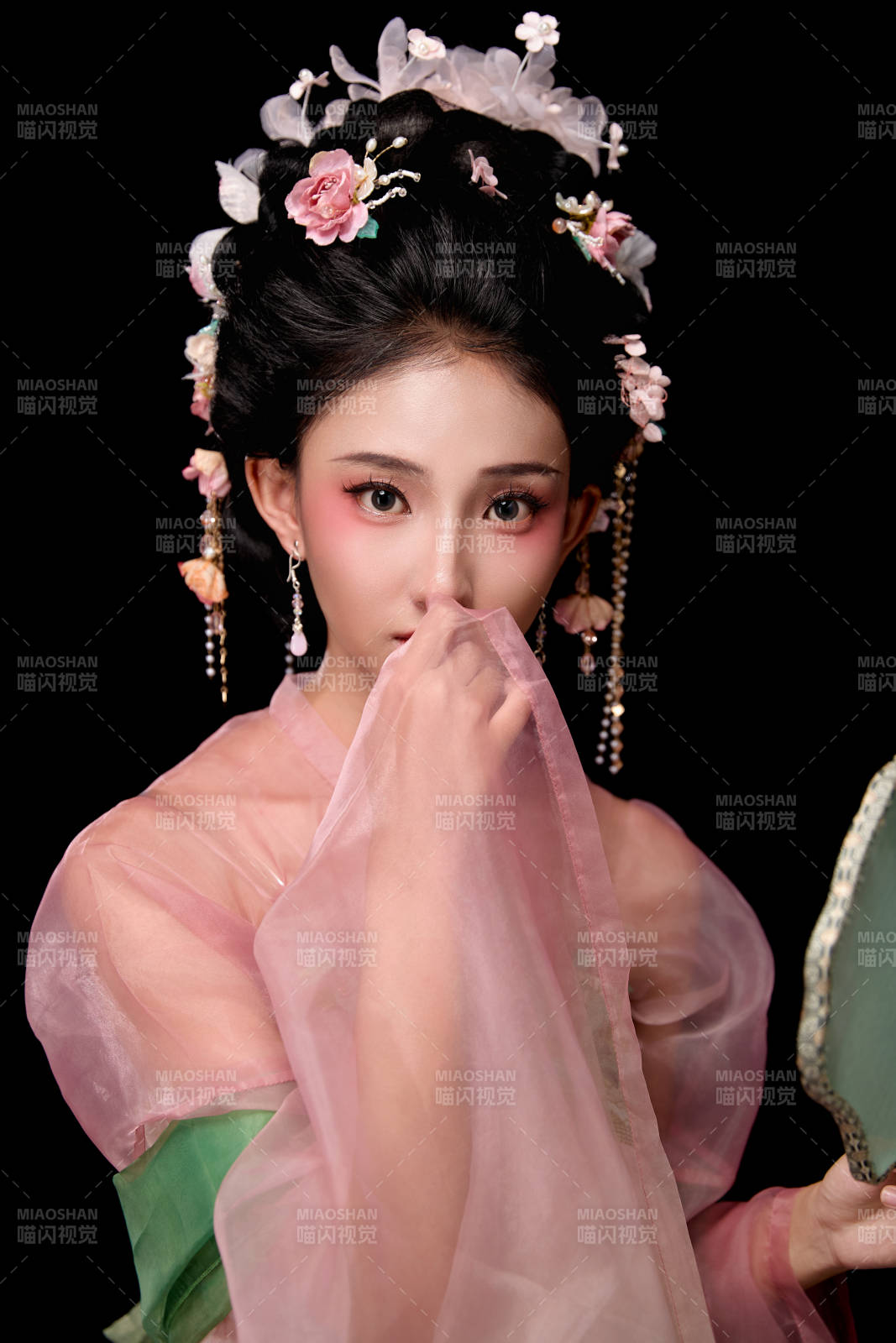 身着唐代宫廷簪花仕女服手持轻扇的女性图片