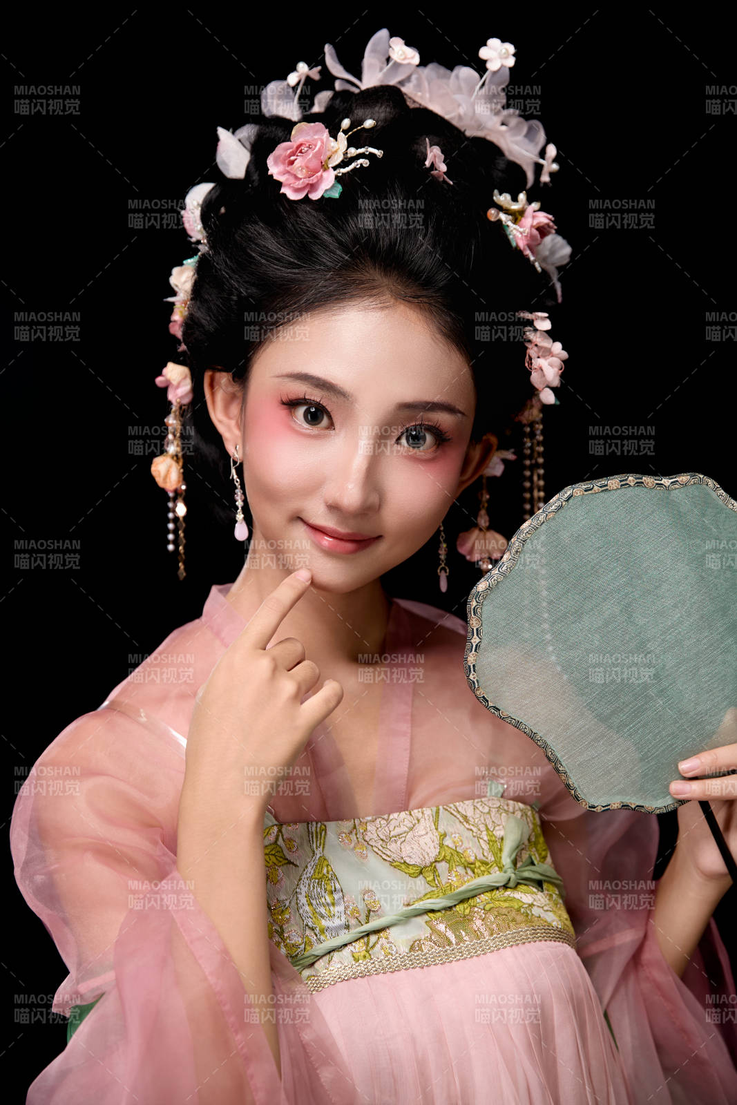 身着唐代宫廷簪花仕女服手持轻扇的女性图片