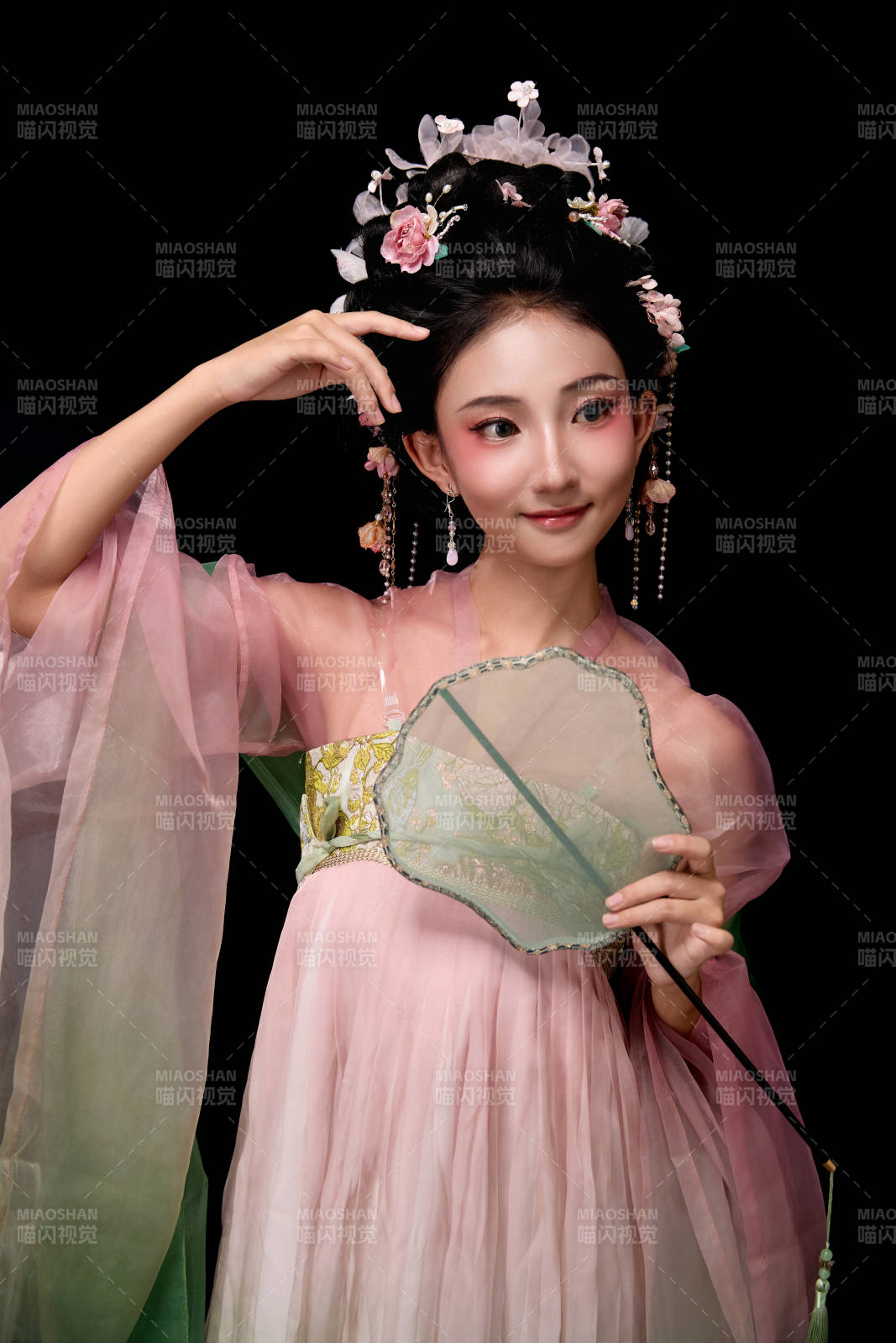 身着唐代宫廷簪花仕女服手持轻扇的女性图片