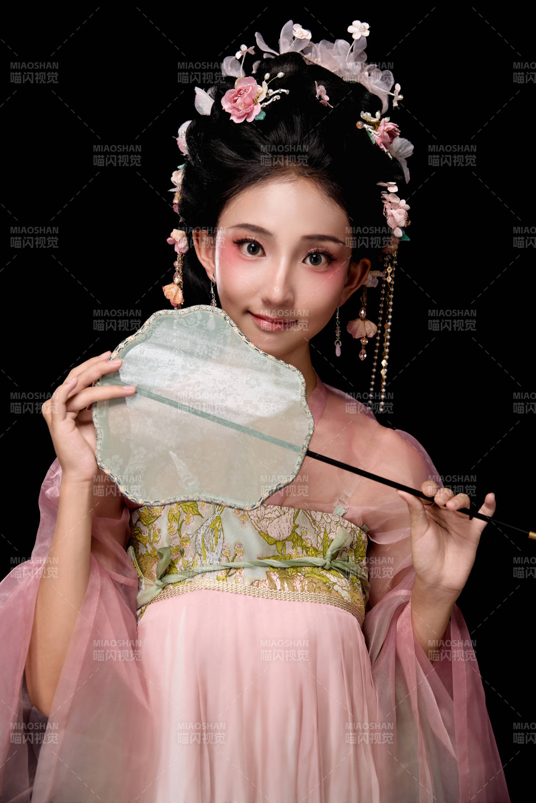 身着唐代宫廷簪花仕女服手持轻扇的女性图片