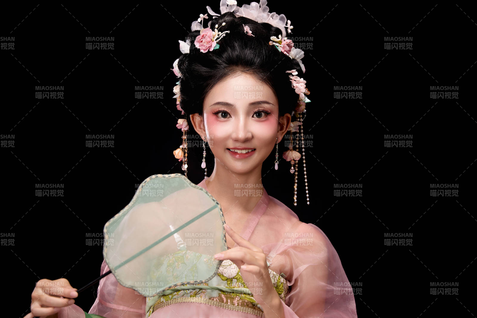 身着唐代簪花仕女服手持轻扇的坐姿女性图片