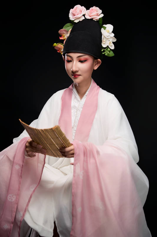 身着粤剧戏曲反串装扮手持竹简的青年女性图片