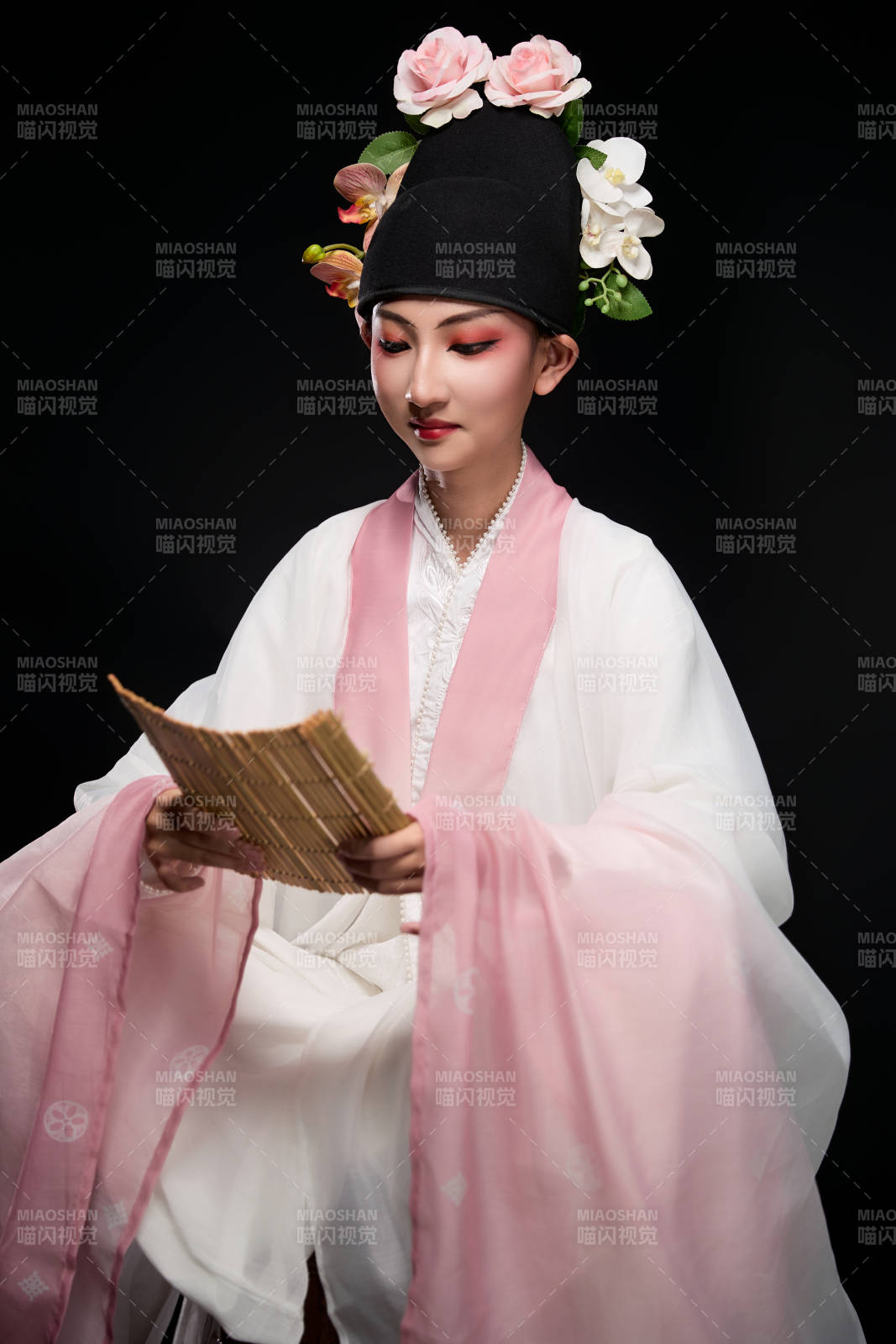 身着粤剧戏曲反串装扮手持竹简的青年女性图片