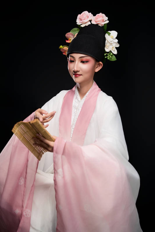 身着粤剧戏曲反串装扮手持竹简的青年女性图片