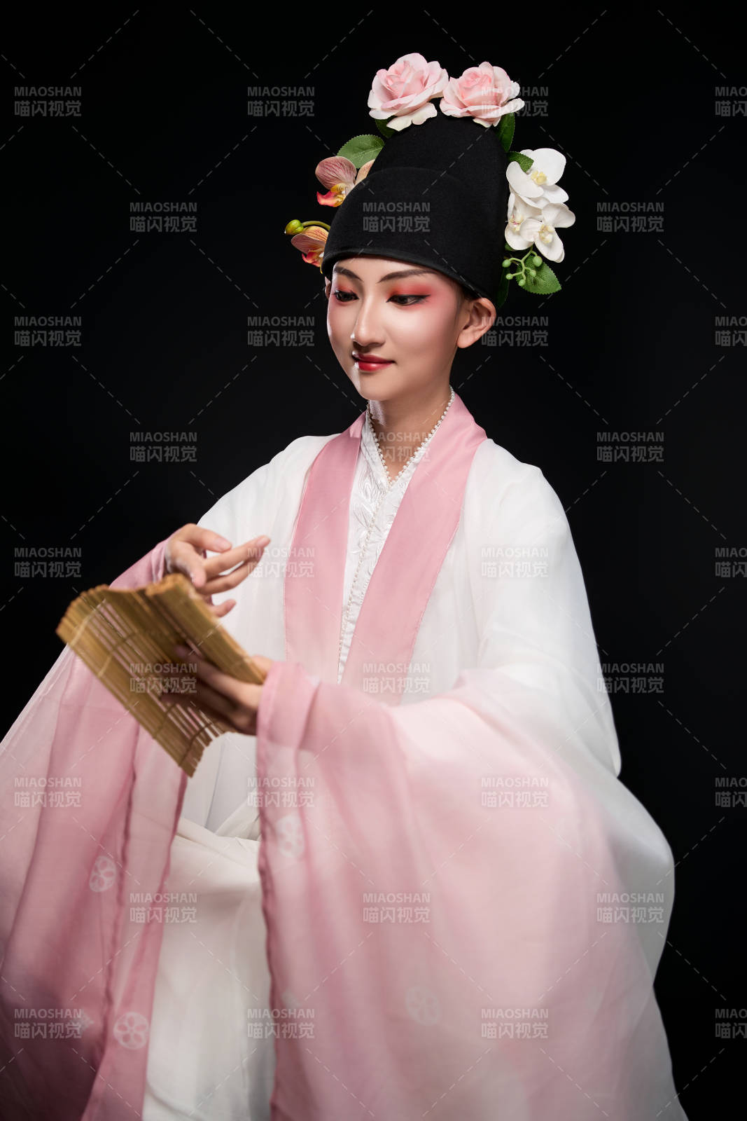 身着粤剧戏曲反串装扮手持竹简的青年女性图片