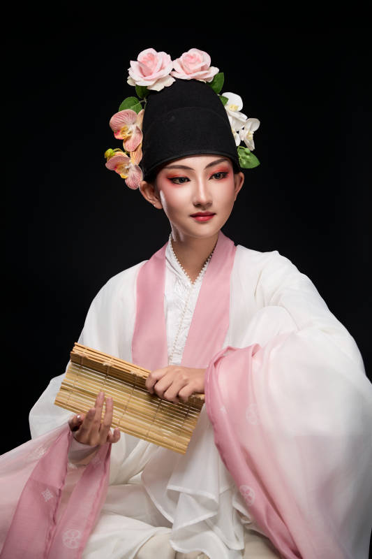 身着粤剧戏曲反串装扮手持竹简的青年女性图片